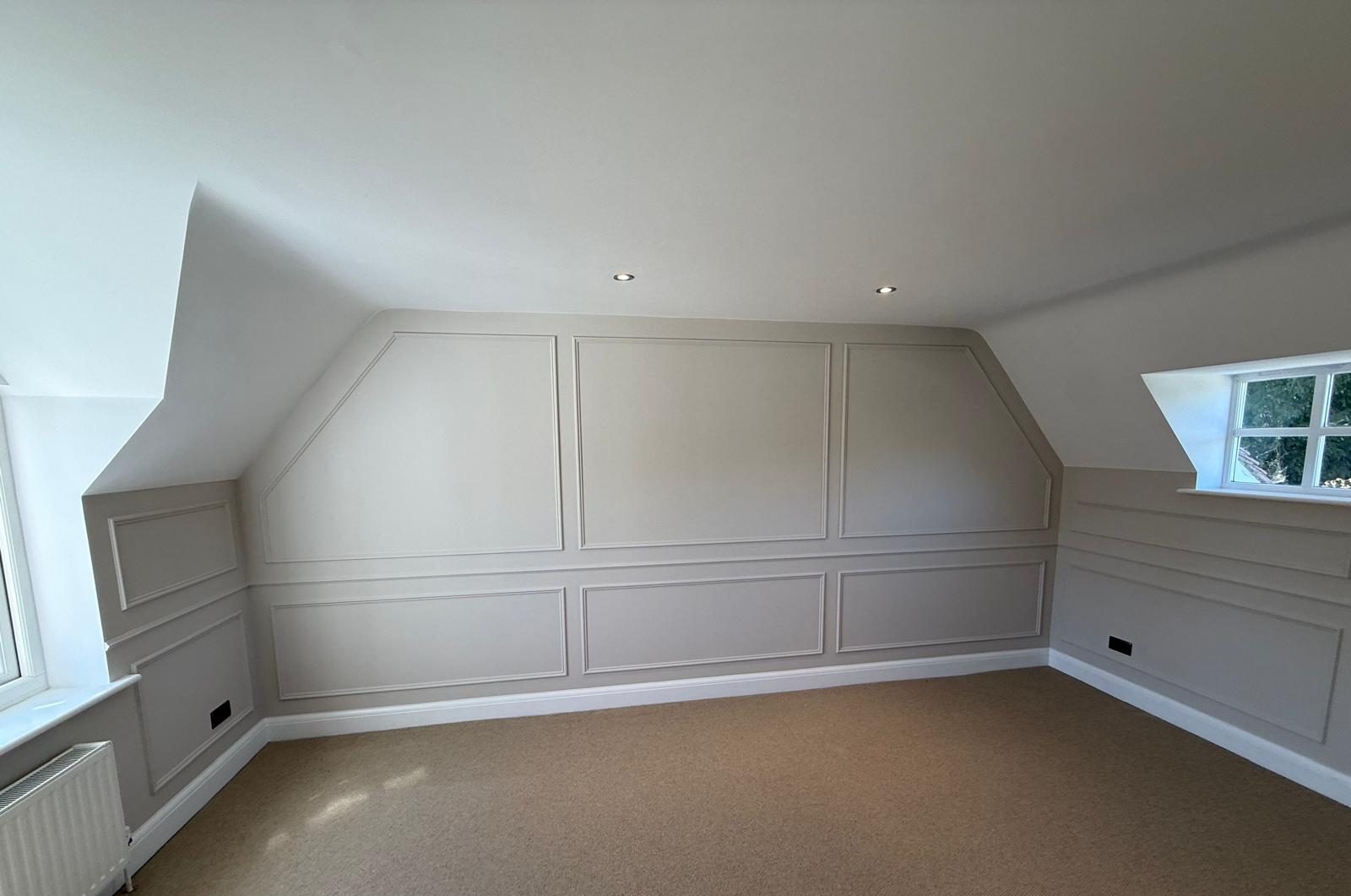 Fitted wall panelling and decoration across a loft bedroom wall and dormer window reveal, Esher